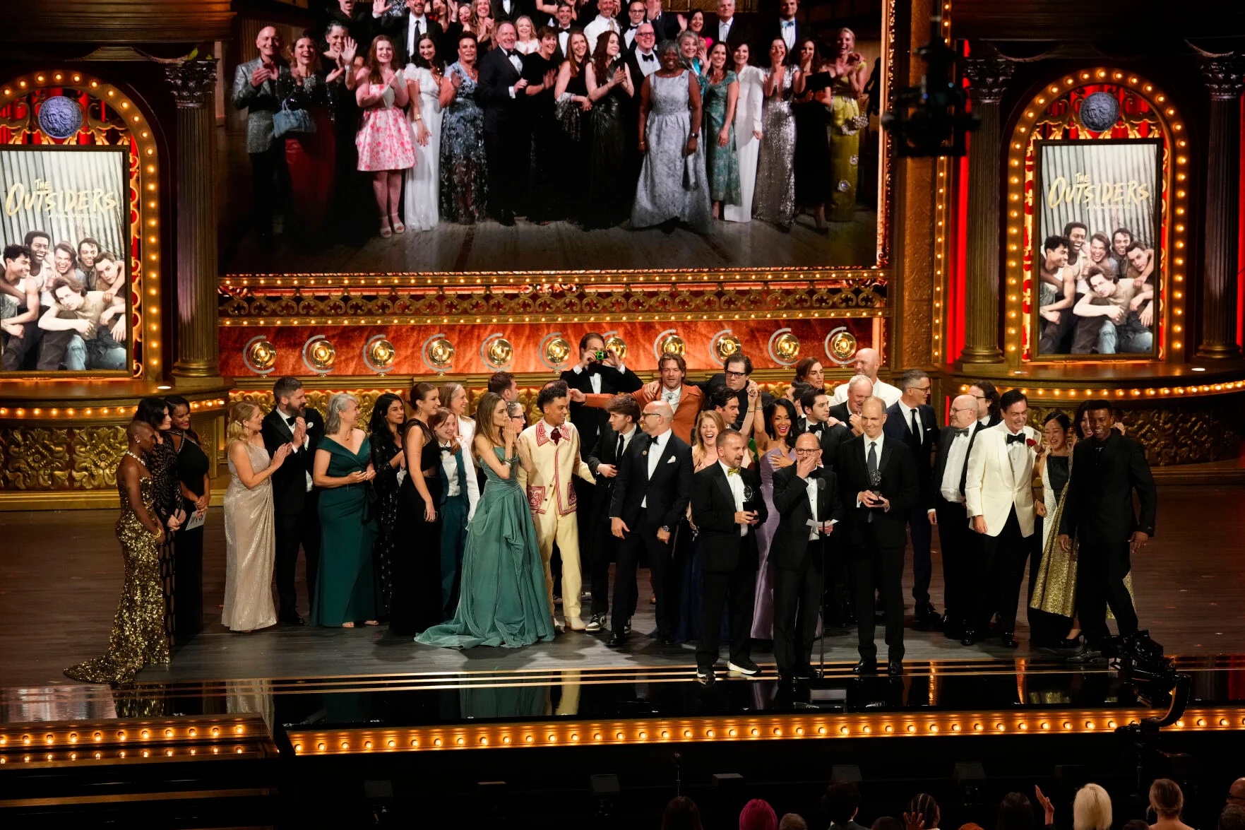 Photo Credit: Michael Rego, from center left, Matthew Rego, and Hank Unger and members of the company of The Outsiders accept the award for Best Musical during the 77th Tony Awards on Sunday, June 16, 2024, in New York. (Charles Sykes/Invision/AP)